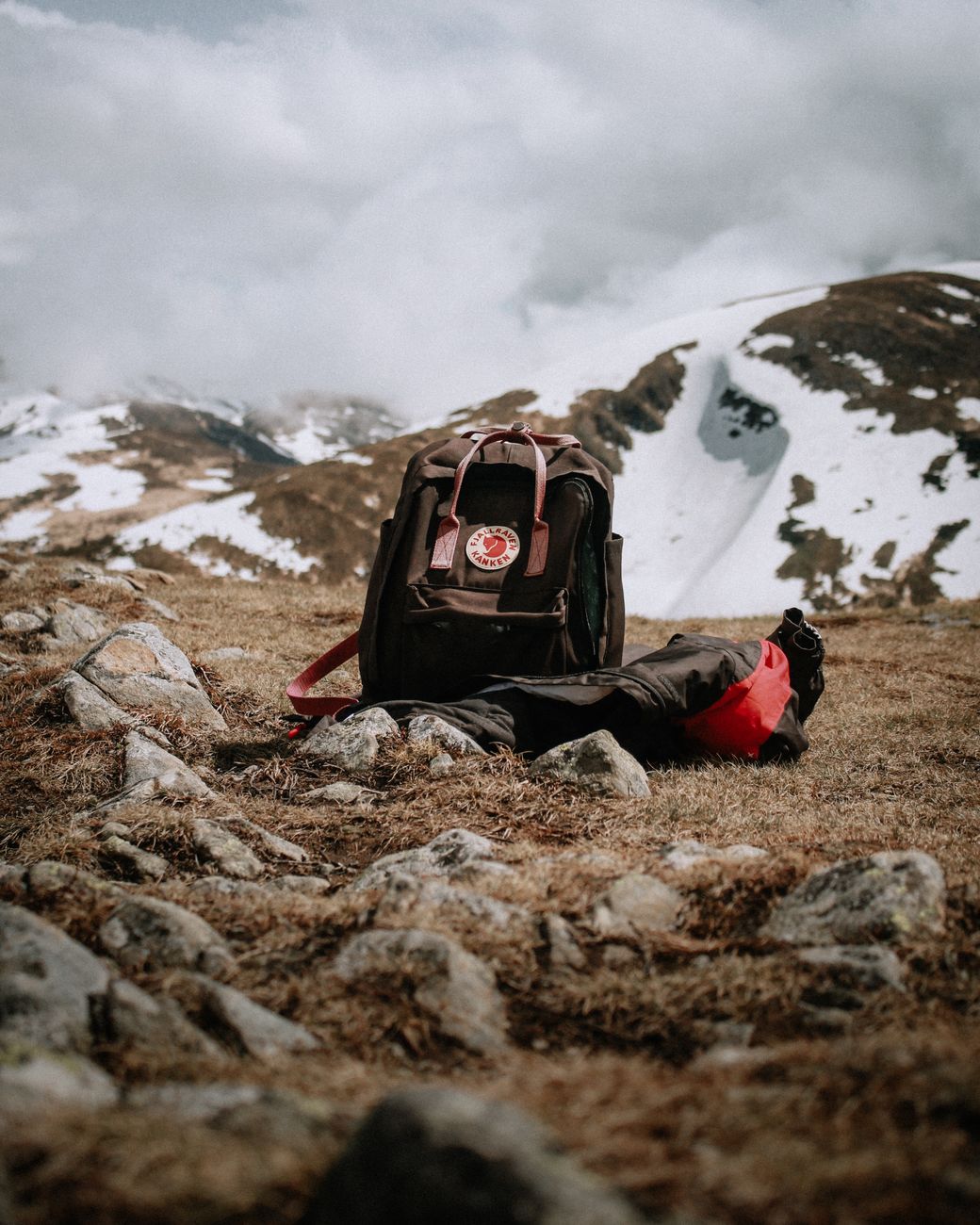 Traveler carrying lightweight rucksack along mountain ridge